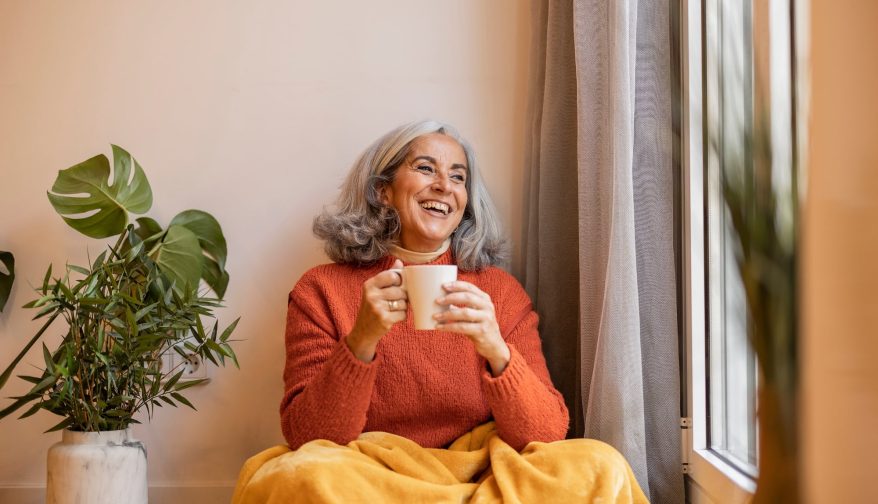 Portrait happy healthy older senior woman sitting at home and drinking coffee. next to the window. Portrait happy healthy older senior woman sitting at home and drinking coffee. next to the window.